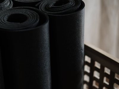 Close up of a black yoga mat on dark floor