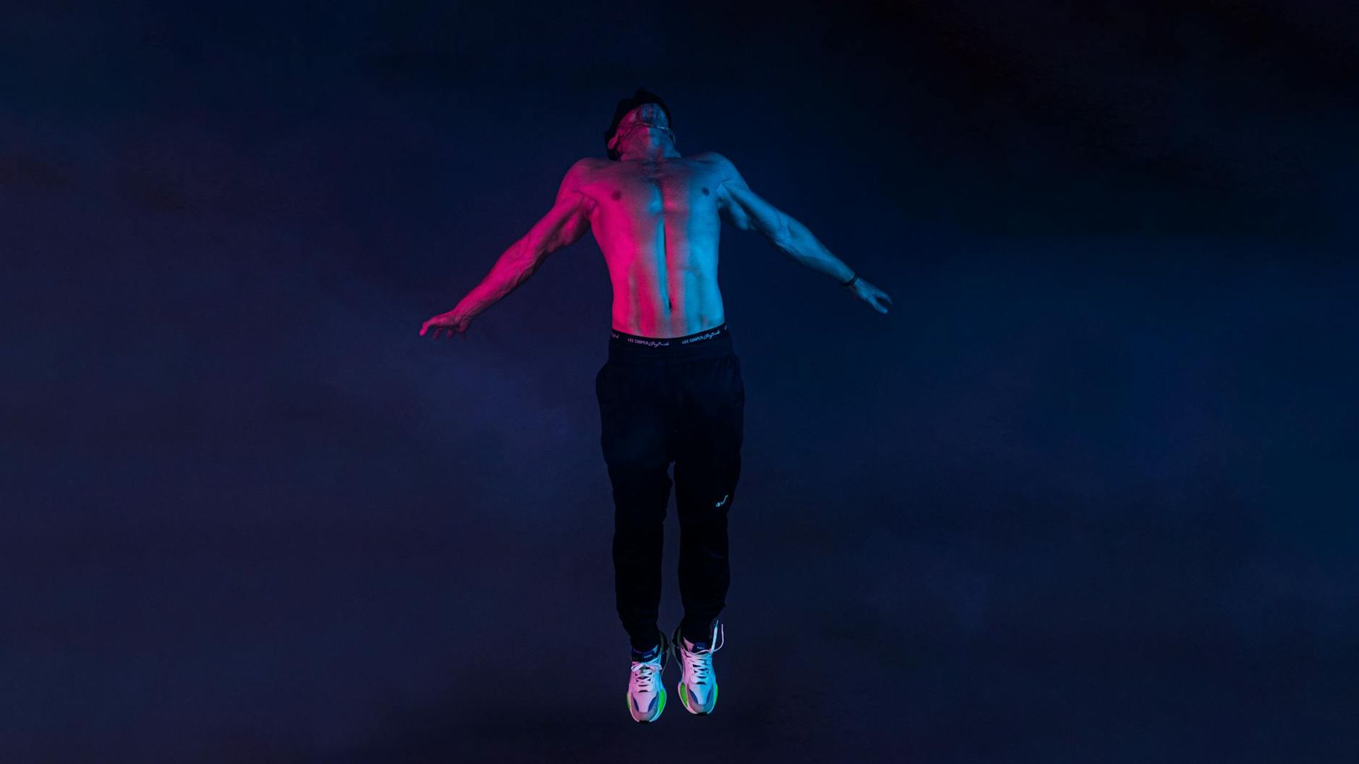 Man performing dynamic exercise in a dark atmosphere